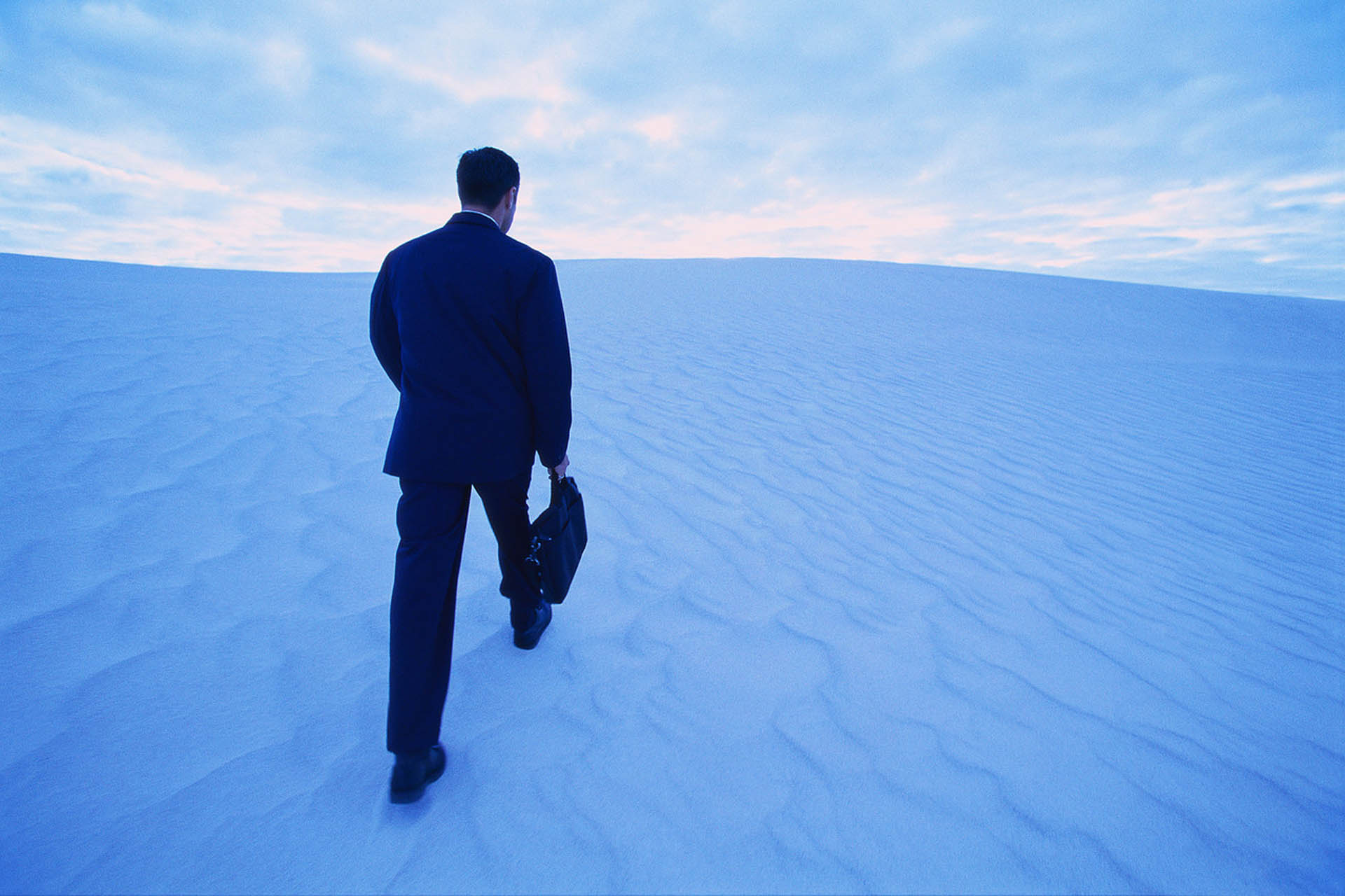 Businessman Walking up Sand Dune - THINK SAVVY